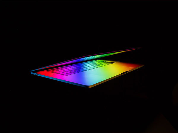 Laptop và bàn phím được chiếu sáng trong không gian tối